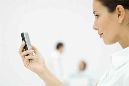 simsearch:695-03380514,k - Woman looking at cell phone, side view, cropped Stock Photo - Premium Royalty-Free, Code: 696-03402553