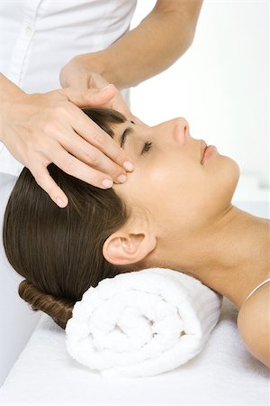 Woman receiving head massage, lying down with her eyes closed, cropped view Stock Photo - Premium Royalty-Free, Code: 696-03402623