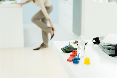 simsearch:632-02645076,k - Professional woman getting dressed, focus on baby bottle and toys in foreground Fotografie stock - Premium Royalty-Free, Codice: 696-03402679