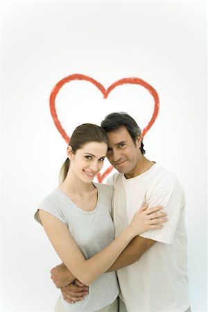 painted heart images - Couple hugging each other in front of heart painted on wall, smiling at camera Stock Photo - Premium Royalty-Free, Code: 696-03402691