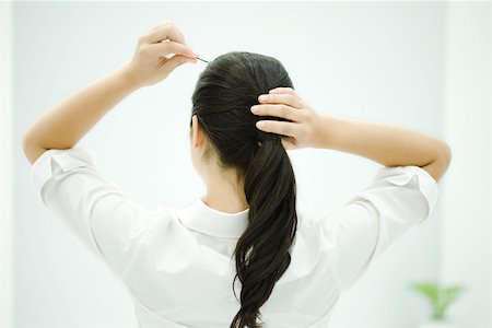 simsearch:696-03402720,k - Woman putting hair in ponytail, arms raised, rear view Foto de stock - Sin royalties Premium, Código: 696-03402720