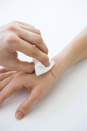 Person holding gauze against wounded hand, cropped view Stock Photo - Premium Royalty-Free, Code: 696-03402744