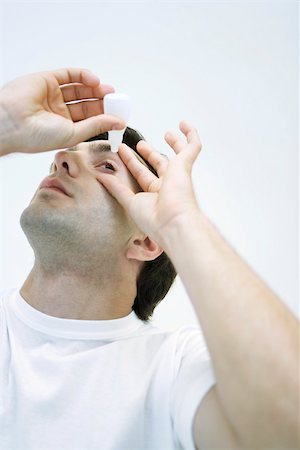 Man applying eye drops, head back Foto de stock - Sin royalties Premium, Código: 696-03402741