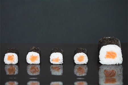 simsearch:695-03390144,k - Maki sushi in a row, one piece larger than the others Foto de stock - Sin royalties Premium, Código: 696-03402768