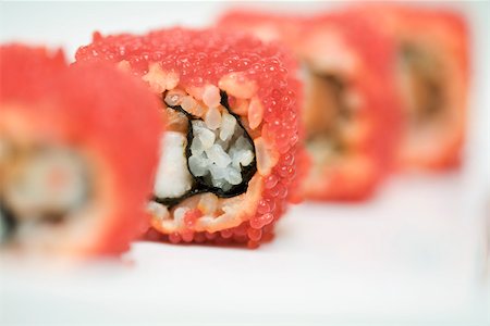 simsearch:632-05604152,k - Cropped view of maki sushi rolled in red flying fish roe, close-up Foto de stock - Sin royalties Premium, Código: 696-03402783