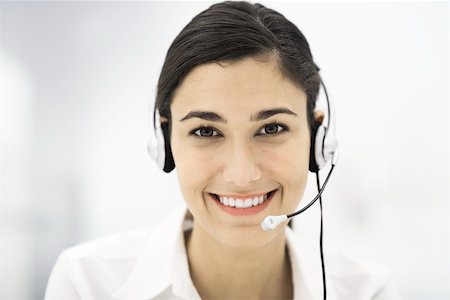 simsearch:696-03402790,k - Woman wearing headset, smiling at camera, portrait Stock Photo - Premium Royalty-Free, Code: 696-03402797