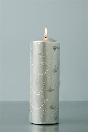 Solitary silver advent candle, burning Stock Photo - Premium Royalty-Free, Code: 696-03402828