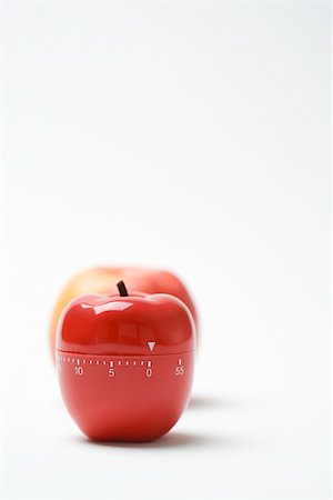 Apple shaped kitchen timer, real apple in background Stock Photo - Premium Royalty-Free, Code: 696-03402873