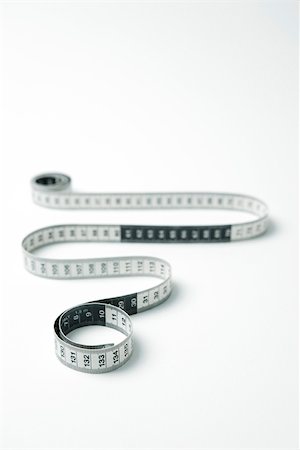 simsearch:633-02345844,k - Measuring tape coiled in snakelike manor Stock Photo - Premium Royalty-Free, Code: 696-03402884