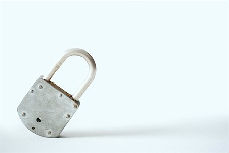Metal padlock tilted to one side, close-up Stock Photo - Premium Royalty-Free, Code: 696-03402914