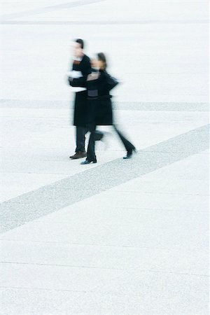 Businessman and businesswoman walking together across public square Stock Photo - Premium Royalty-Free, Code: 696-03402952