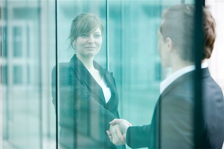 politics - Businesswoman and businessman meet and shake hands at building entrance Stock Photo - Premium Royalty-Free, Code: 696-03403012