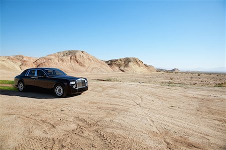 simsearch:693-05552680,k - Black eco-friendly Rolls Royce car running off-road on unpaved road Fotografie stock - Premium Royalty-Free, Codice: 693-05552683