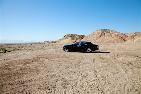 rich lifestyle car - Rolls Royce car parked on unpaved road with tire tracks Stock Photo - Premium Royalty-Free, Code: 693-05552691