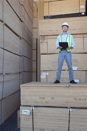 Portrait of a worker standing on stack of plywood Foto de stock - Sin royalties Premium, Código: 693-05552704