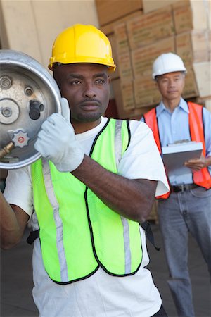 simsearch:694-03330301,k - Warehouse worker carrying cylinder with manager in background Foto de stock - Sin royalties Premium, Código: 693-05552717