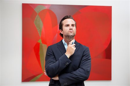 simsearch:693-05552741,k - Young adult man thinking in front of painting in art gallery Stock Photo - Premium Royalty-Free, Code: 693-05552745