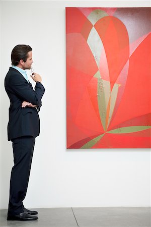 painting of people in a art gallery - Side view of a man looking intensely towards painting Stock Photo - Premium Royalty-Free, Code: 693-05552747