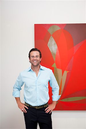 Smiling man with hands on hips in front of wall painting Foto de stock - Sin royalties Premium, Código: 693-05552759