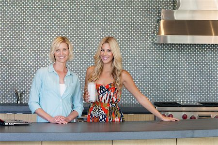 Portrait of smiling senior mother and daughter standing in kitchen Stock Photo - Premium Royalty-Free, Code: 693-05552955