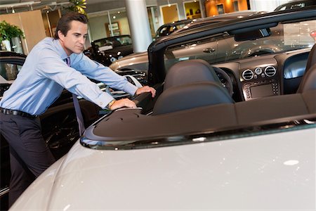 Car salesperson leaning on car Stock Photo - Premium Royalty-Free, Code: 693-05552988