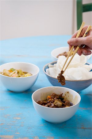 Close of human hand with chopsticks holding food Stock Photo - Premium Royalty-Free, Code: 693-05553238