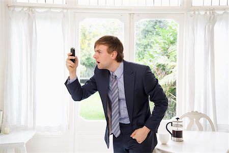 people shocked on phones - Surprised businessman looking at his cell phone Stock Photo - Premium Royalty-Free, Code: 693-05553255