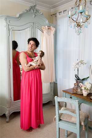 Drag queen wearing nightwear holding doll Stock Photo - Premium Royalty-Free, Code: 693-05553329