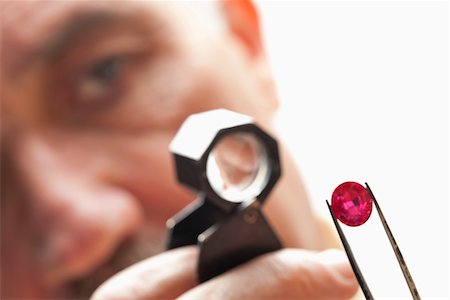 pinzette - Close up of gemstone with jeweler looking through magnifying glass Fotografie stock - Premium Royalty-Free, Codice: 693-05553382