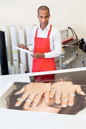 photograph print - Homme travaillant à la presse à imprimer avec les impressions photo sur table Photographie de stock - Premium Libres de Droits, Code: 693-05794021