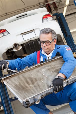 Mechanic working on an auto part of an car with a wrench Stock Photo - Premium Royalty-Free, Code: 693-05794042