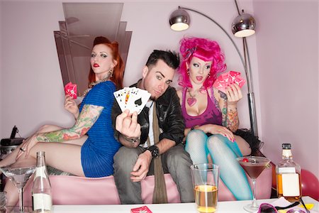 Man showing playing cards tattooed sexy women sitting besides Stock Photo - Premium Royalty-Free, Code: 693-05794168