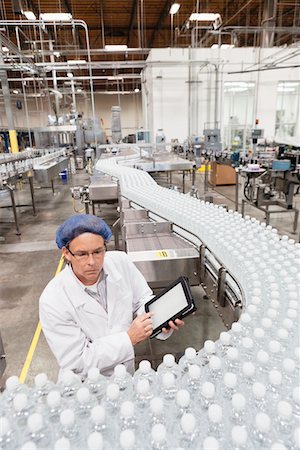 simsearch:6113-07160300,k - Vision grand angle de l'homme examine les bouteilles à l'usine d'embouteillage Photographie de stock - Premium Libres de Droits, Code: 693-05794247