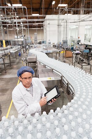 High angle view of man examining bottles at bottling plant Foto de stock - Sin royalties Premium, Código: 693-05794247