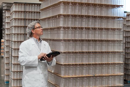 Man inspecting bottled water in distribution warehouse Foto de stock - Sin royalties Premium, Código: 693-05794240