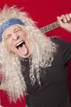 sacando la lengua - Close-up of middle-aged male guitarist sticking out tongue over colored background Foto de stock - Sin royalties Premium, Código: 693-05794303