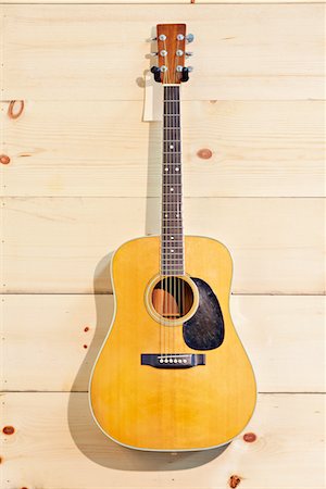 Martin guitar hanged against wood grain wall Foto de stock - Royalty Free Premium, Número: 693-05794334