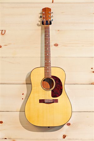 Steel-string acoustic guitar on wood grain wall Foto de stock - Royalty Free Premium, Número: 693-05794335