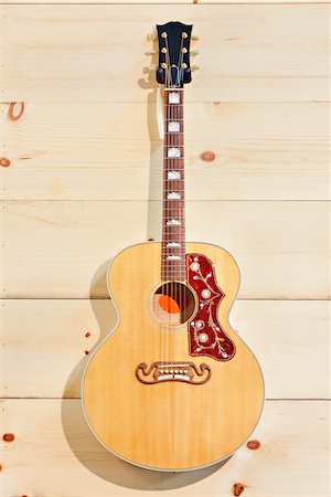 retail and interior and nobody - Acoustic guitar with label on a wood grain wall Stock Photo - Premium Royalty-Free, Code: 693-05794333