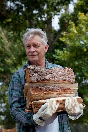 Senior man carrying firewood Stock Photo - Premium Royalty-Free, Code: 693-05794384