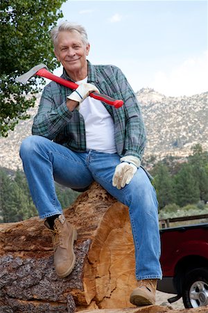 sylviculture - Lumberjack sitting on huge tree trunk with an axe Foto de stock - Sin royalties Premium, Código: 693-05794391