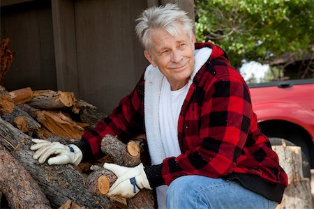 Senior man sitting besides firewood log Stock Photo - Premium Royalty-Free, Code: 693-05794407