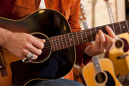 Close-up of man's torso practicing with guitar Foto de stock - Sin royalties Premium, Código: 693-05794447