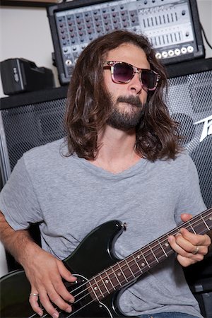 simsearch:693-05794451,k - Young man wearing sunglasses practicing with guitar Stock Photo - Premium Royalty-Free, Code: 693-05794452