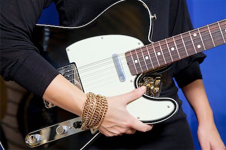 Midsection of young woman holding electric guitar Fotografie stock - Premium Royalty-Free, Codice: 693-05794471