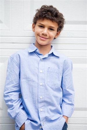 Smiling mixed race boy with hands in pockets Stock Photo - Premium Royalty-Free, Code: 693-05793964