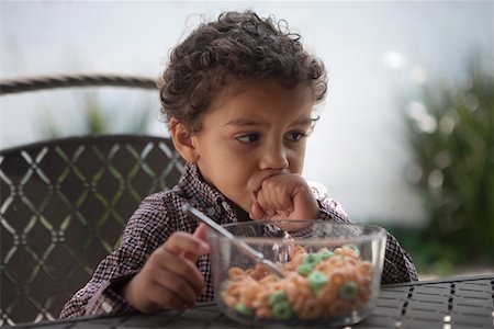 simsearch:693-06021547,k - Pensive little boy looking away with cereal bowl on table Foto de stock - Royalty Free Premium, Número: 693-05793966