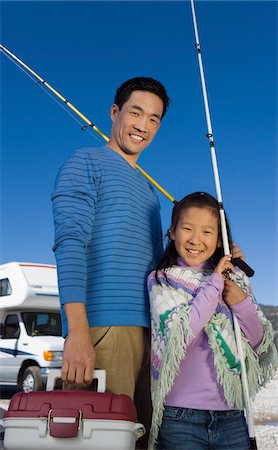 Father and daughter holding fishing poles outside RV Stock Photo - Premium Royalty-Free, Code: 693-06014007