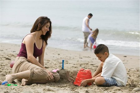 Mère de construire des châteaux de sable avec fils sur la plage Photographie de stock - Premium Libres de Droits, Code: 693-06014087