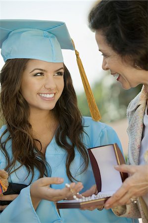 family graduation picture - Graduate Receiving necklace from Grandmother outside Stock Photo - Premium Royalty-Free, Code: 693-06014158